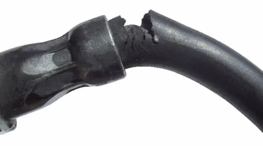 Latiguillo de freno de goma agrietado y roto junto al racor